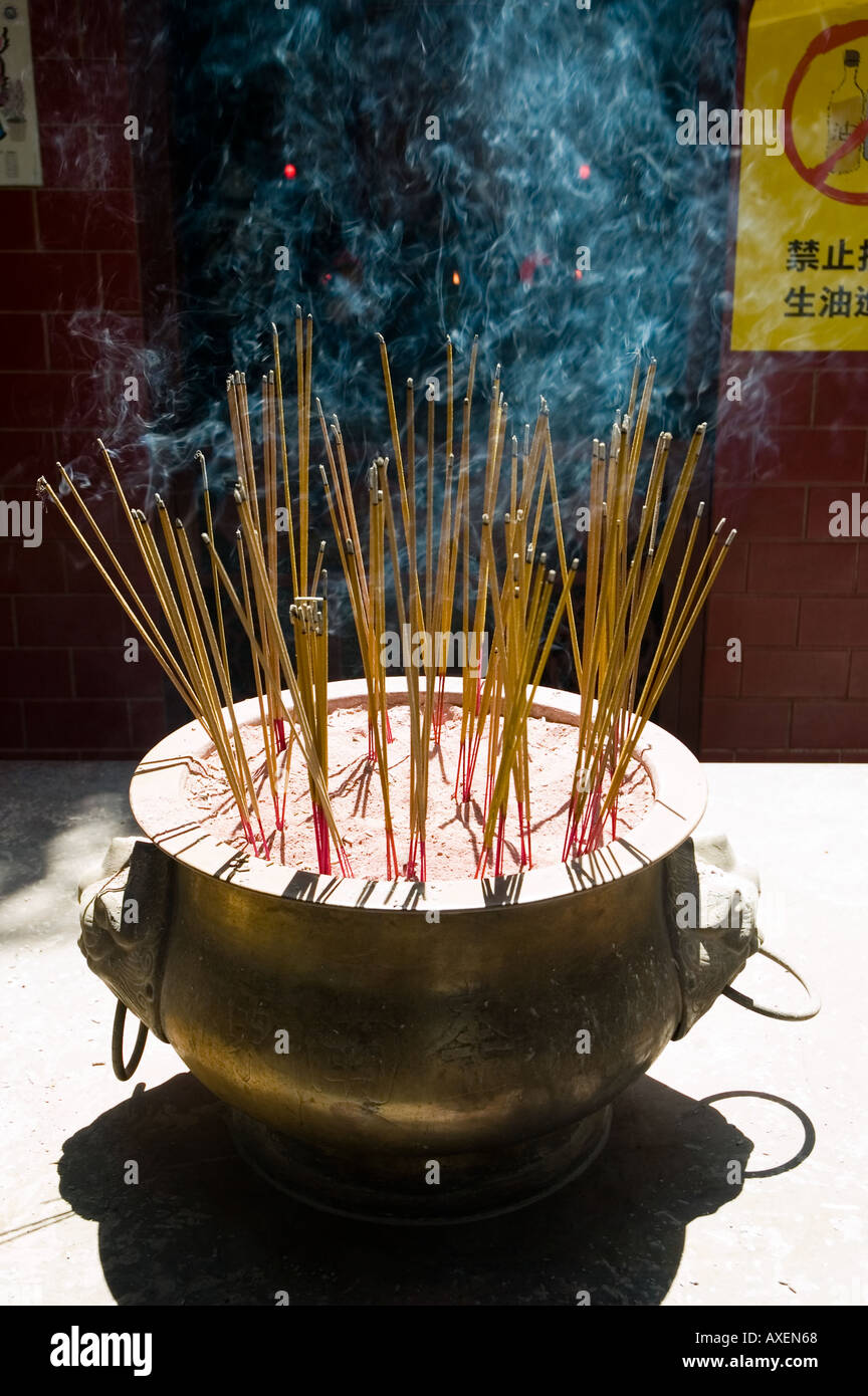 Incense sticks burn in a metal urn at the Wong Tai Sin temple in Hong