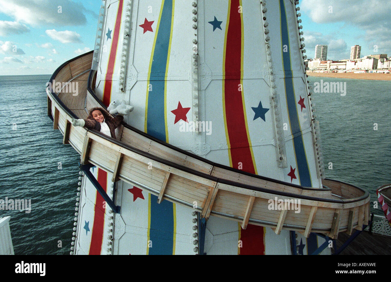 A six year old black girl rides down the Helter Skelter on Brightons Palace  Pier now renamed Brighton Pier on a winter day Stock Photo