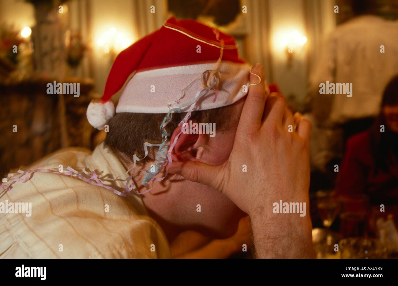 An office worker in a City of London pub, rests his head after a night's drinking in the days before Christmas. Stock Photo