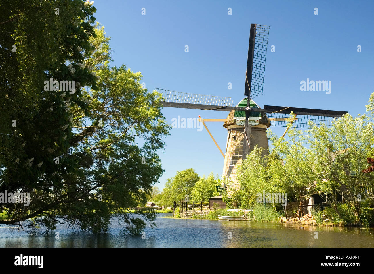 Beautiful dutch windmill in front of a river Taken with polarisation filter on a sunny day Stock Photo