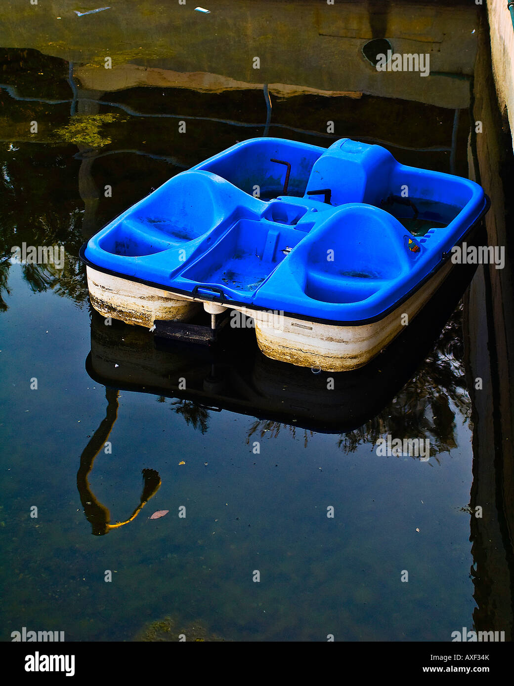 Old paddle boat sitting in a filthy canal waiting to sink Stock Photo