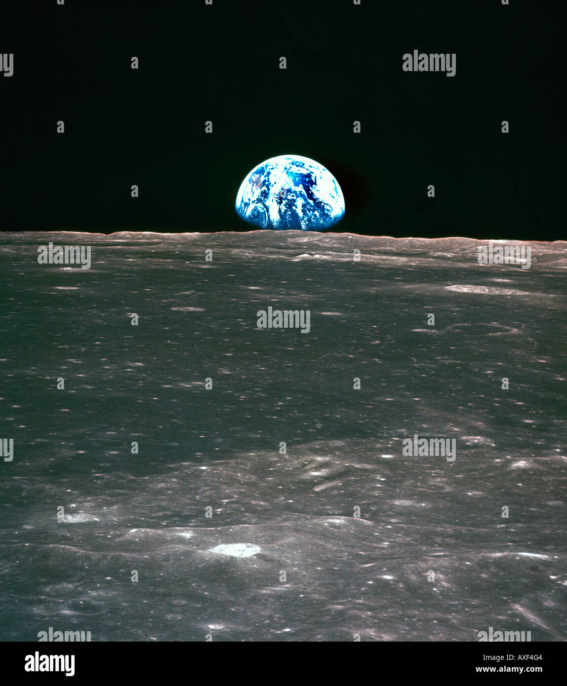 View from Apollo 11 Spacecraft Earth Rising above the Moons Horizon - Lunar Terrain Shown is the Smyth's Sea 20/7/1969 Stock Photo