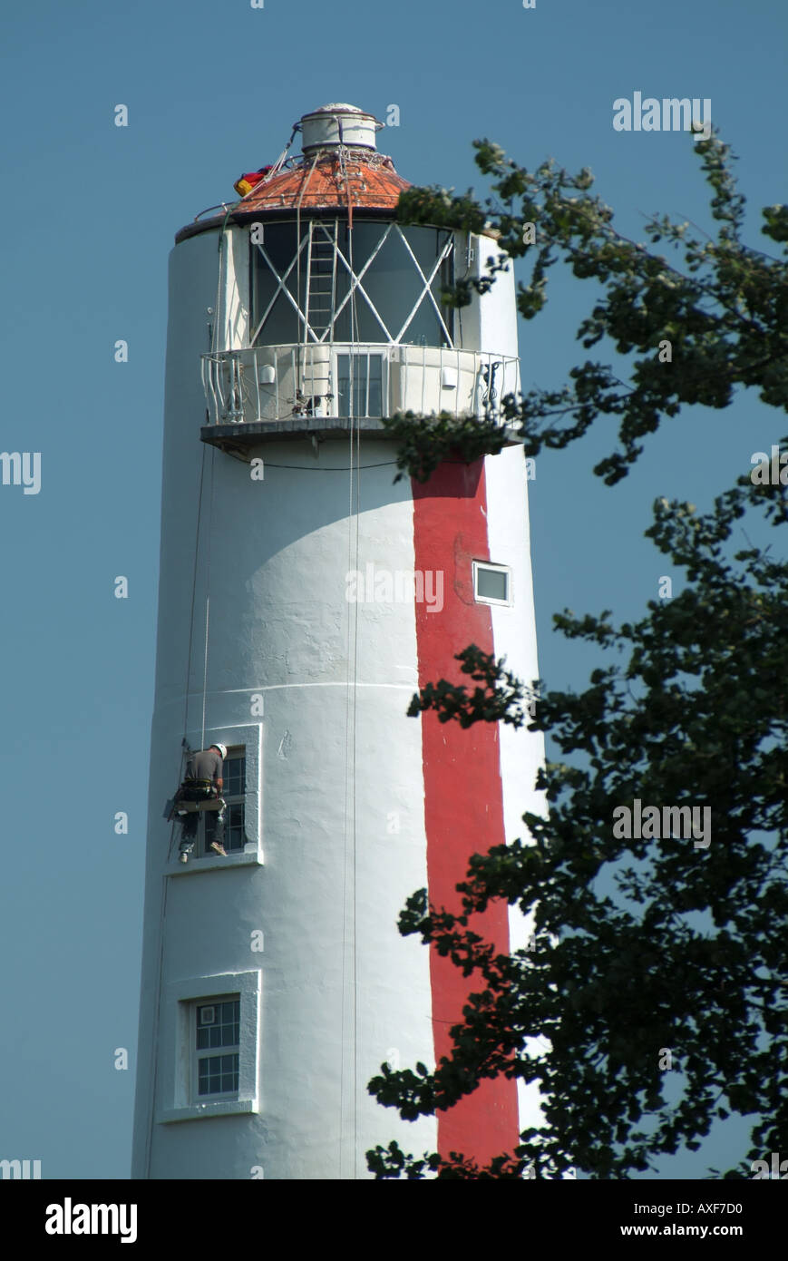 Burnham on Sea workmen on rope cradle carrying out maintenance on The Pillar lighthouse now a private house Stock Photo
