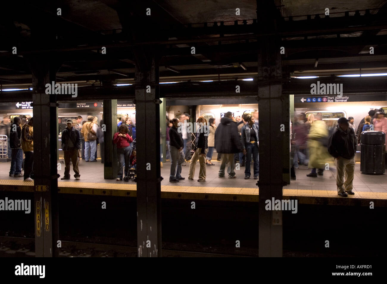 People wait for a train at one of New York’s subway stations. Stock Photo