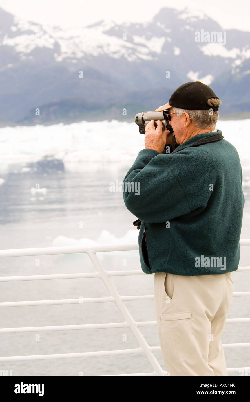 Senior citizen with video camera at Alaskan cruise filming glacier