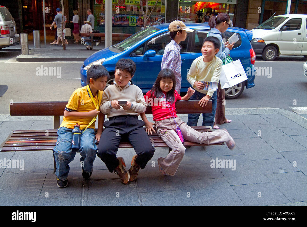 Chinese children on street bench in Sydney Stock Photo