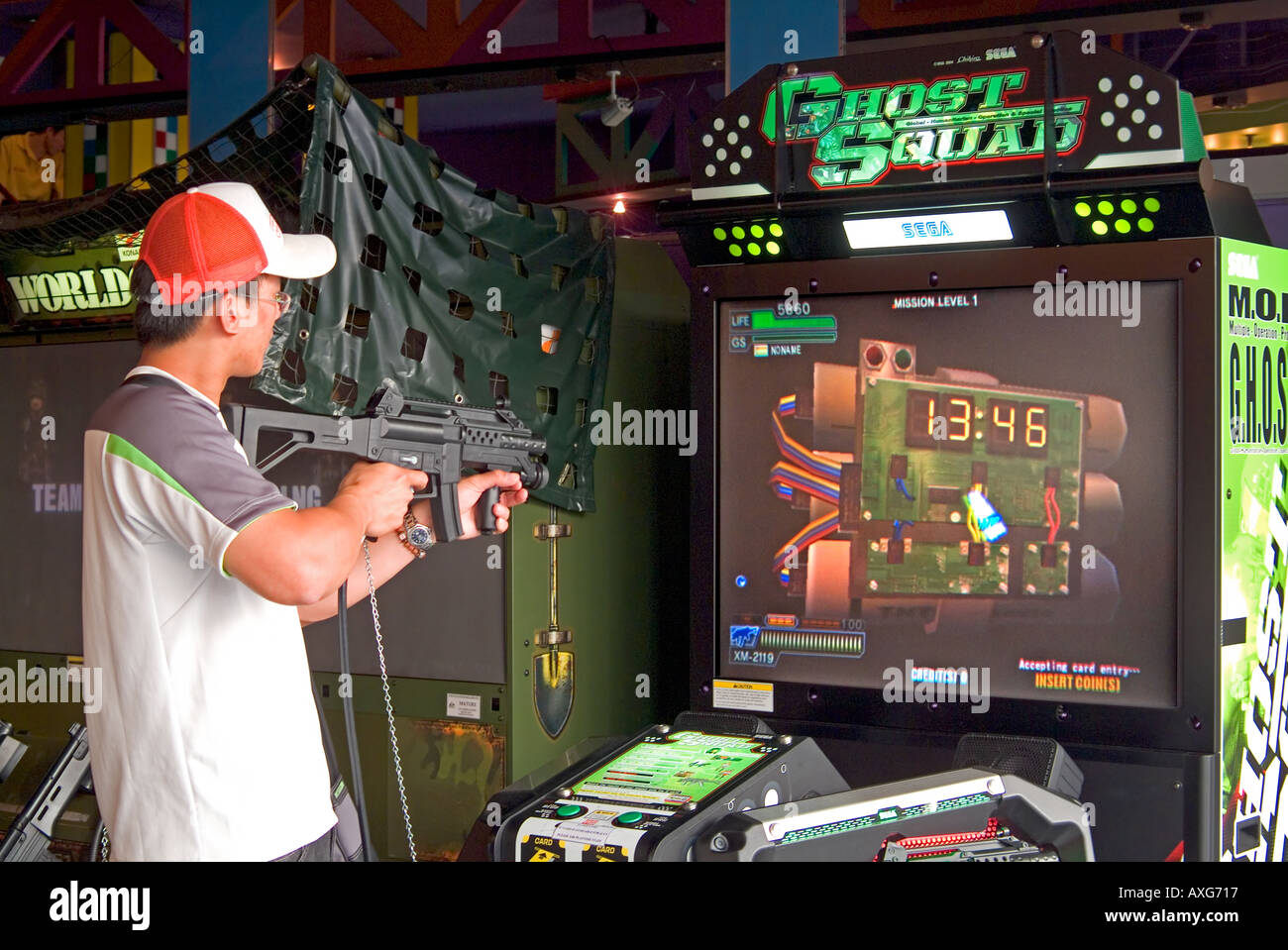 A young man playing a shooting arcade game Stock Photo