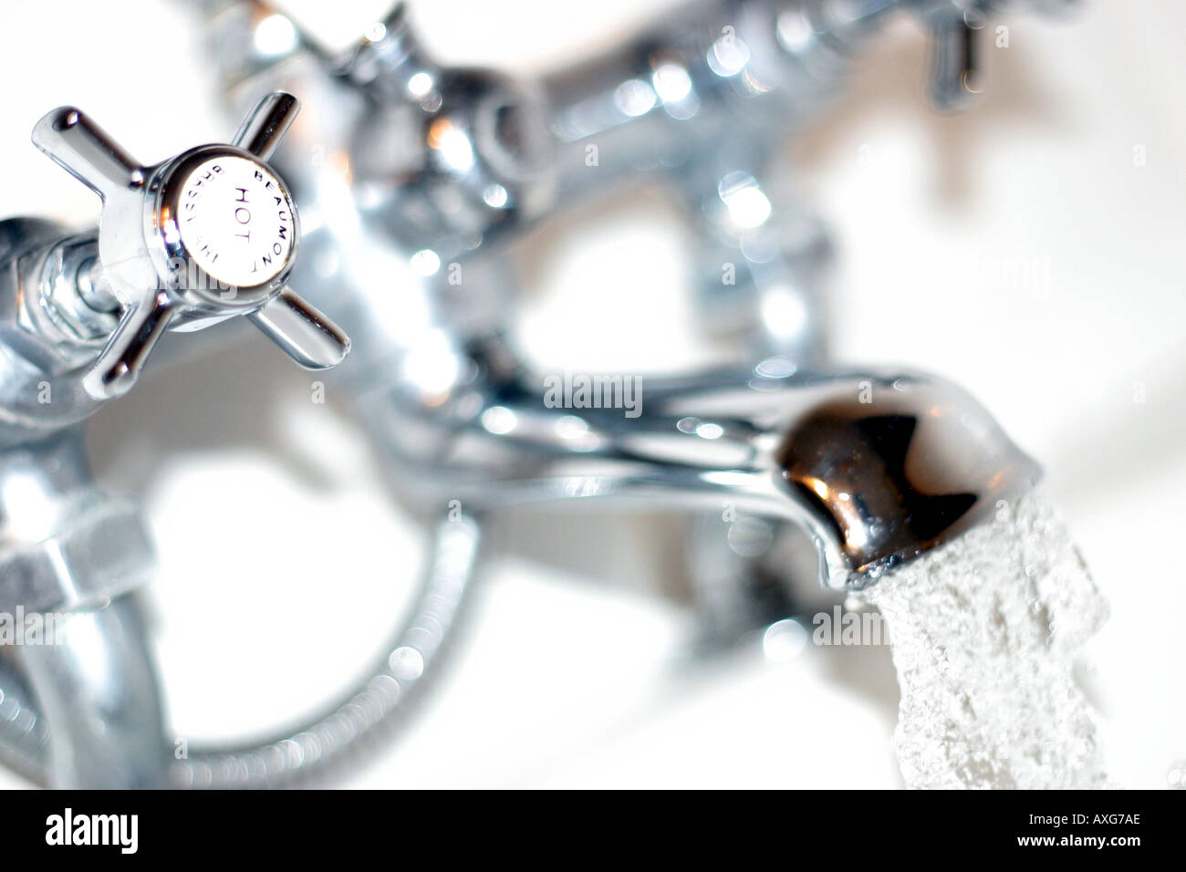 high key shot of water running from old fashioned style mixer tap in