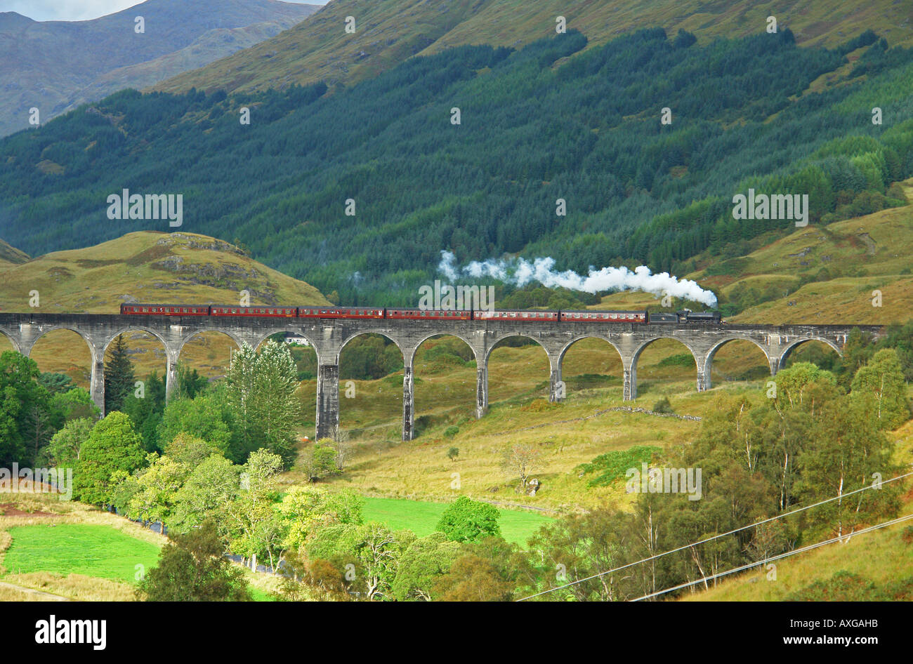 A special charter steam train is passing over the famous Glenfinnan viaduct en route towards Fort William from Mallaig Stock Photo