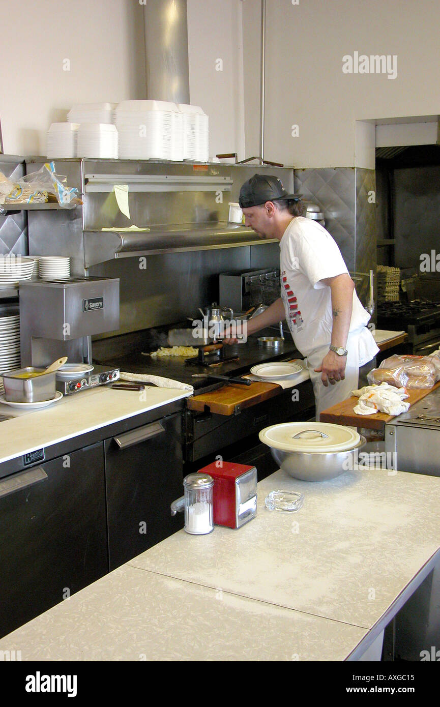 Short order cook prepares meal on a grill in a restaurant Stock Photo