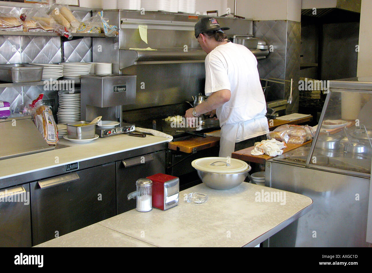 Short order cook prepares meal on a grill in a restaurant Stock Photo