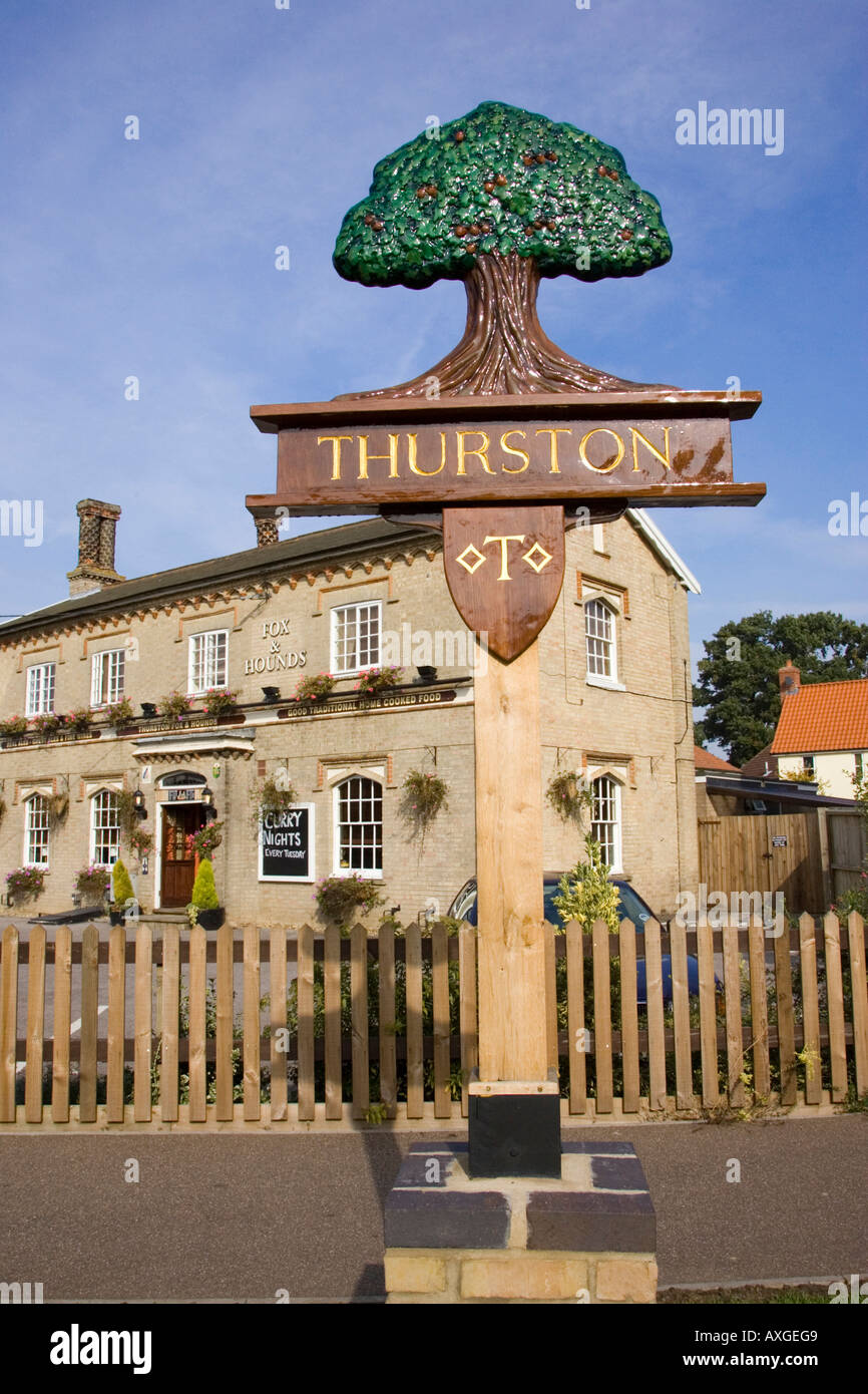 the village sign of Thurston in Suffolk, UK with the Fox & Hounds Pub in the background Stock Photo