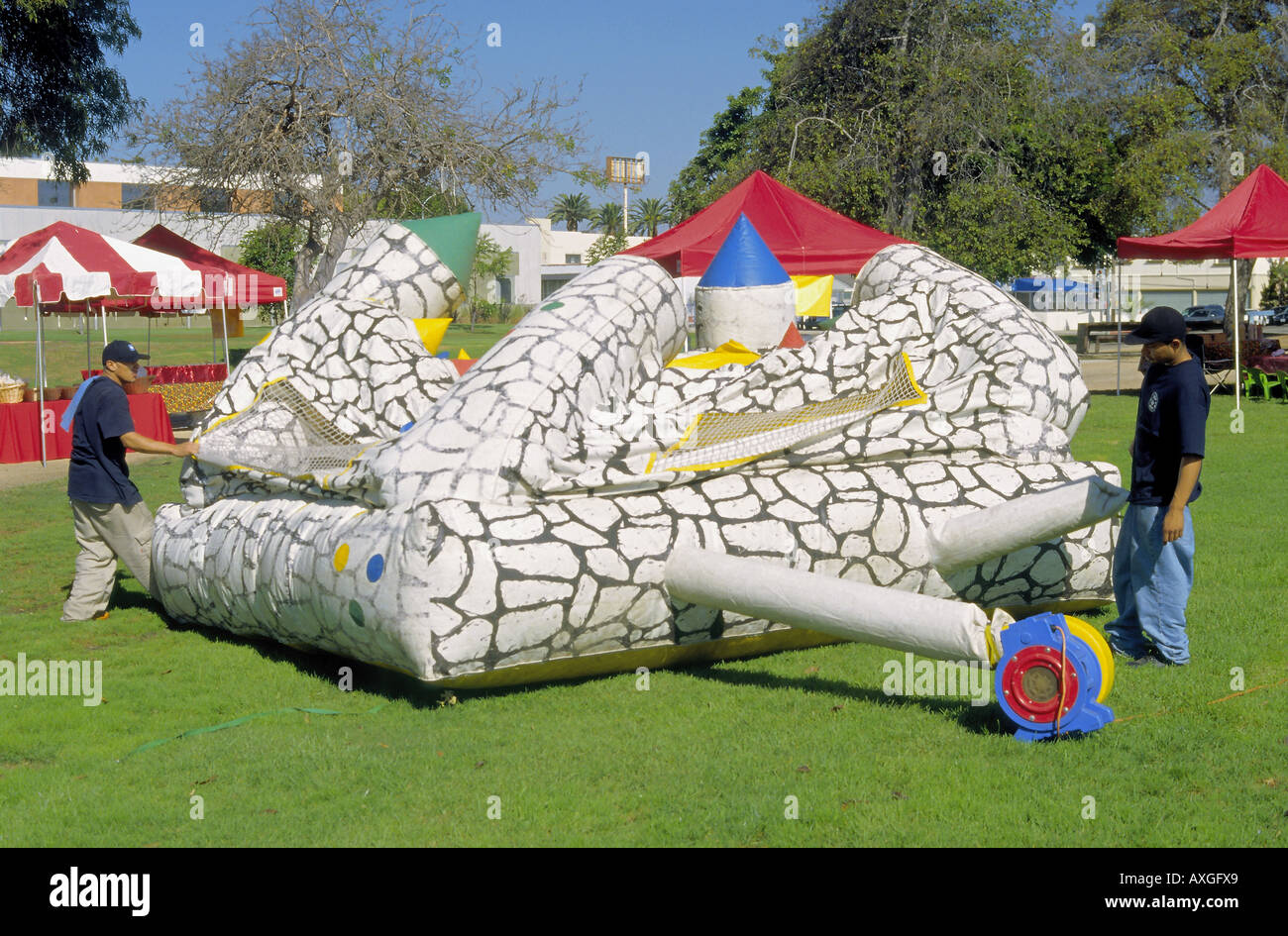 Starting to inflate a playhouse castle for kids in a park in