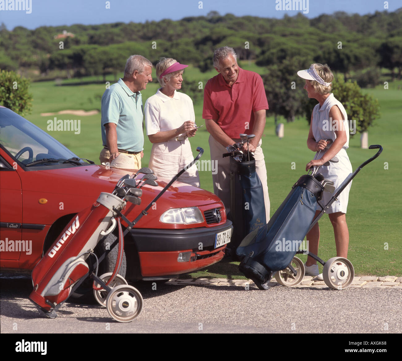 retired age couples on golf course by their hired car Stock Photo