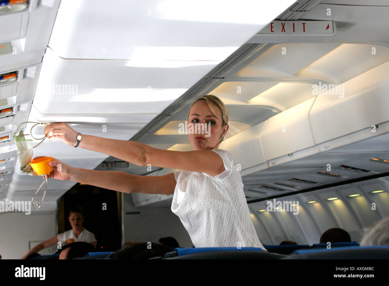 A Flight Attendants Demonstrates Use Of Oxygen Masks During A Pre Stock a-flight-attendants-demonstrates-use-of-oxygen-masks-during-a-pre-stock