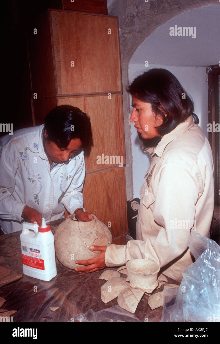 Women archaeologists In a Oaxaca Mexico lab reconstruct ceramic vessels found in a tomb burial. Stock Photo