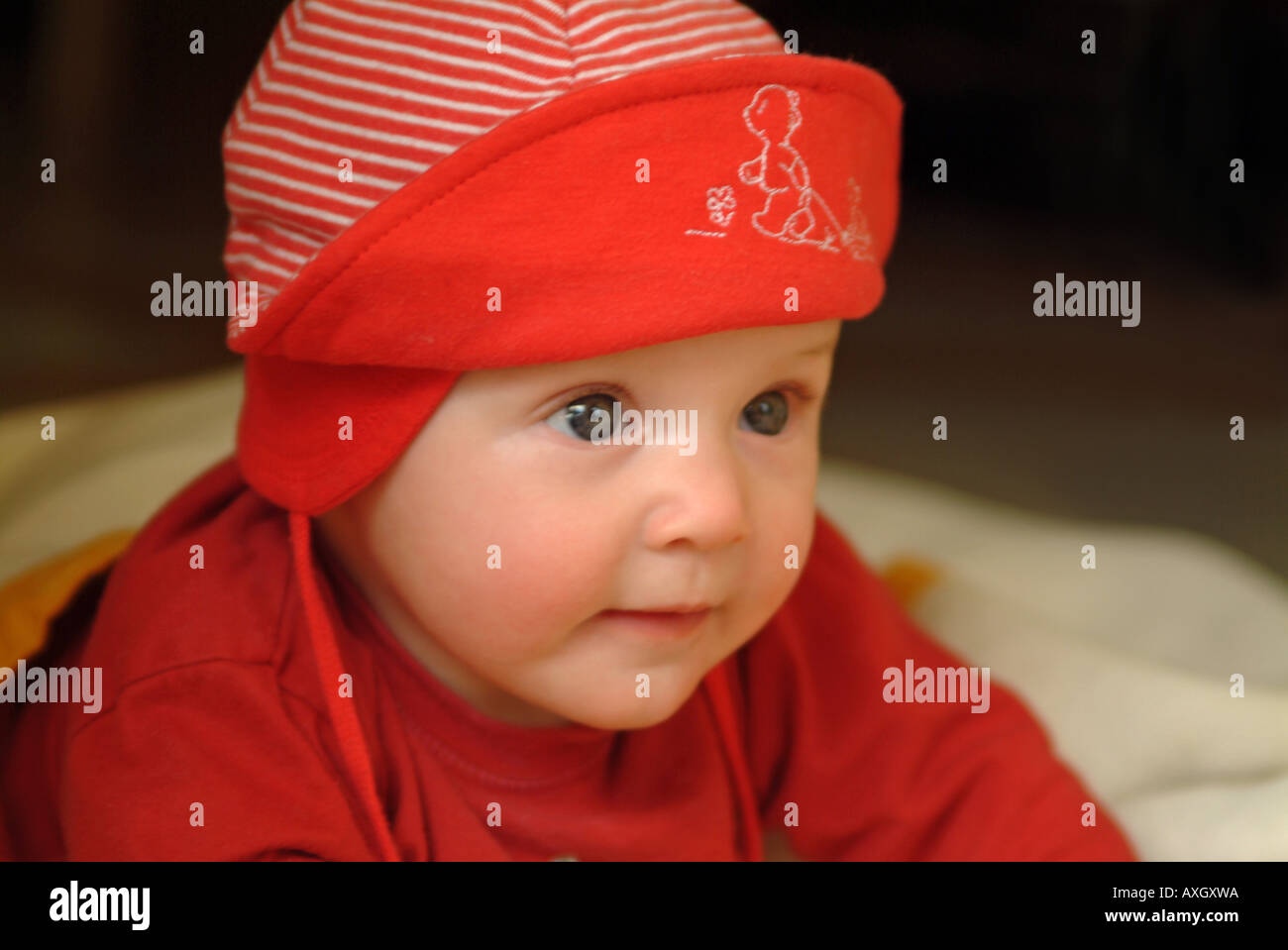 confident 6 months old Baby with cap zufriedenes 6 Monate altes Baby mit Mütze Stock Photo