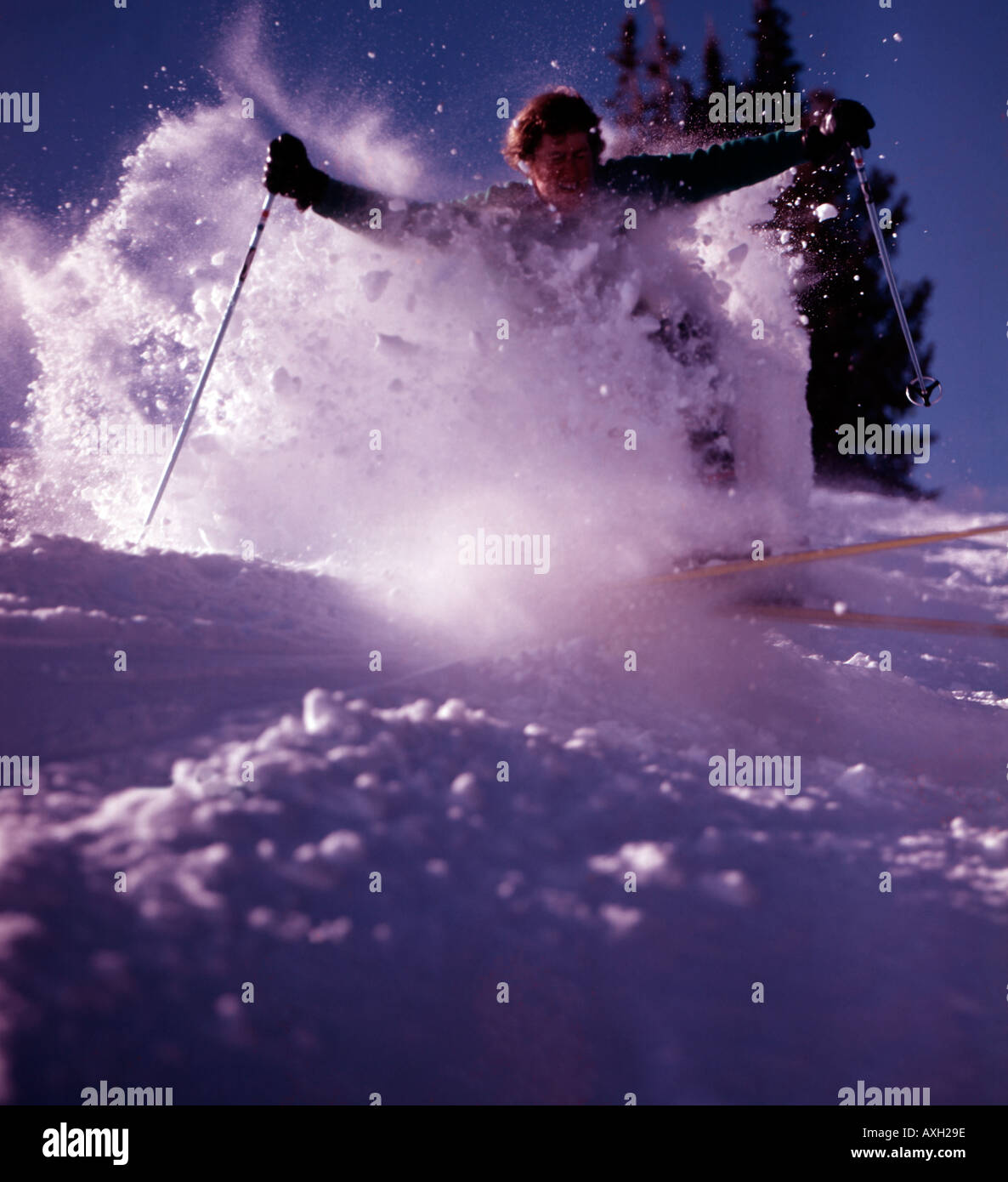 Skier bursting through powder snow creates a cloud of flakes in his wake at Sun Valley Resort in Idaho Stock Photo
