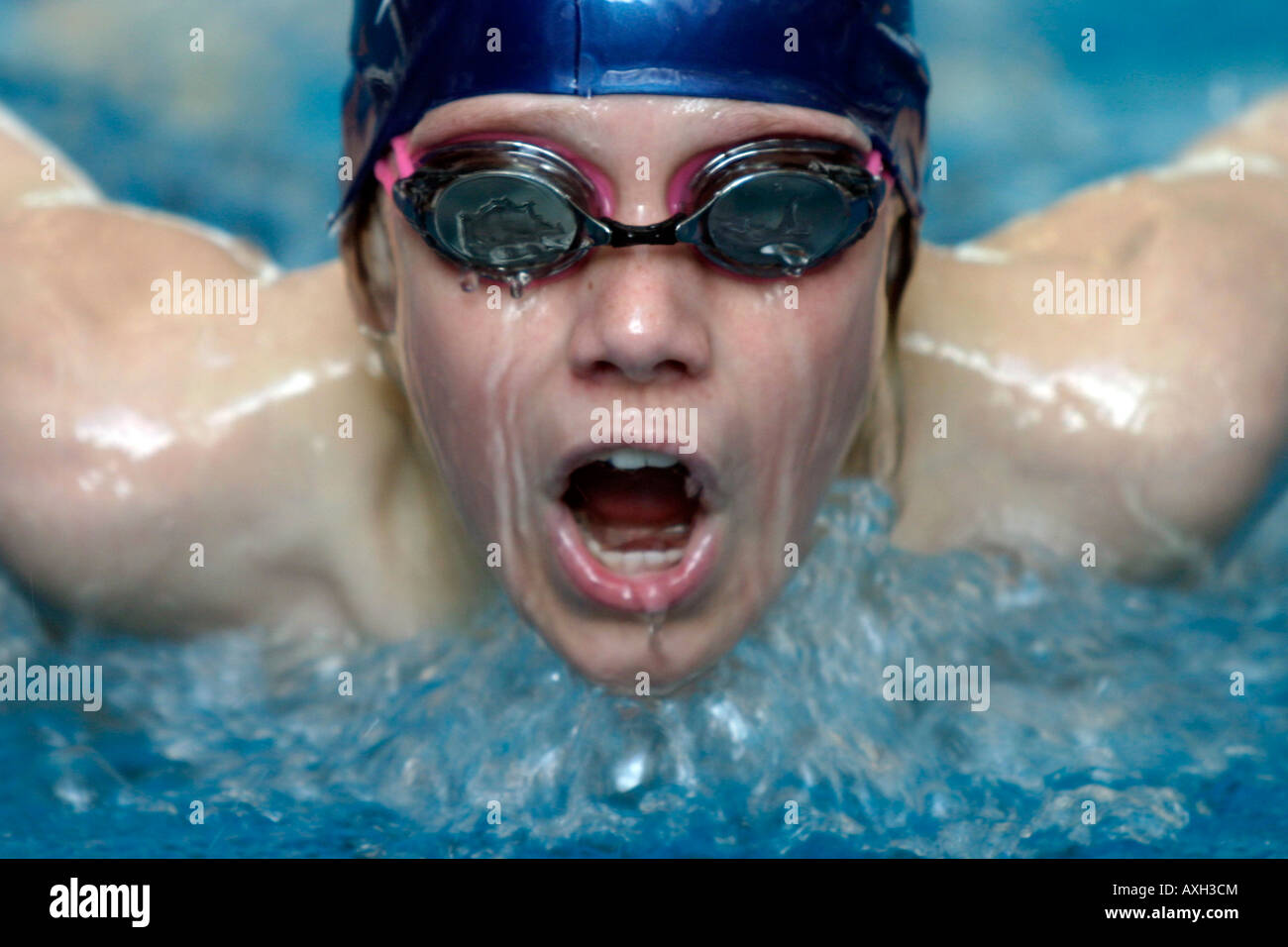 A male swimmer takes a deep breath as he competes during a butterfly