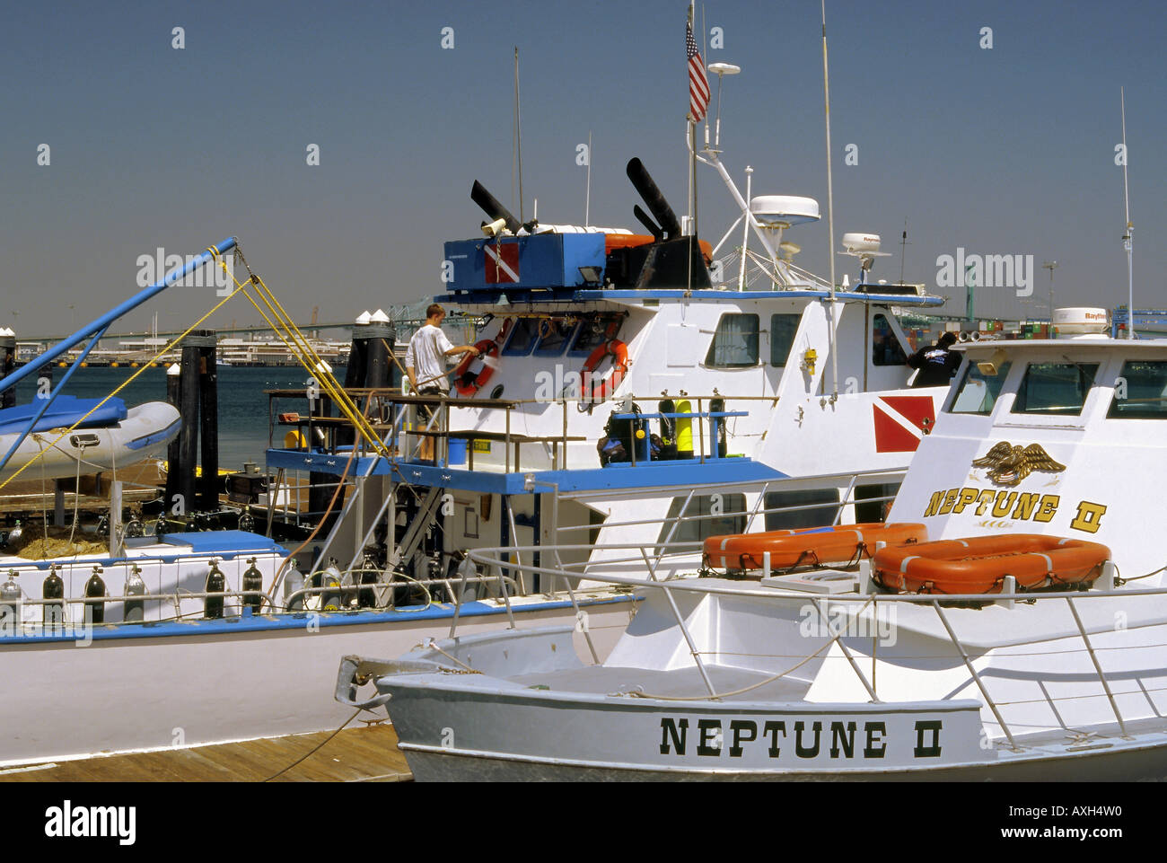 Boat owners engaged in cleaning their vessel in the San Pedro main channel marina Stock Photo