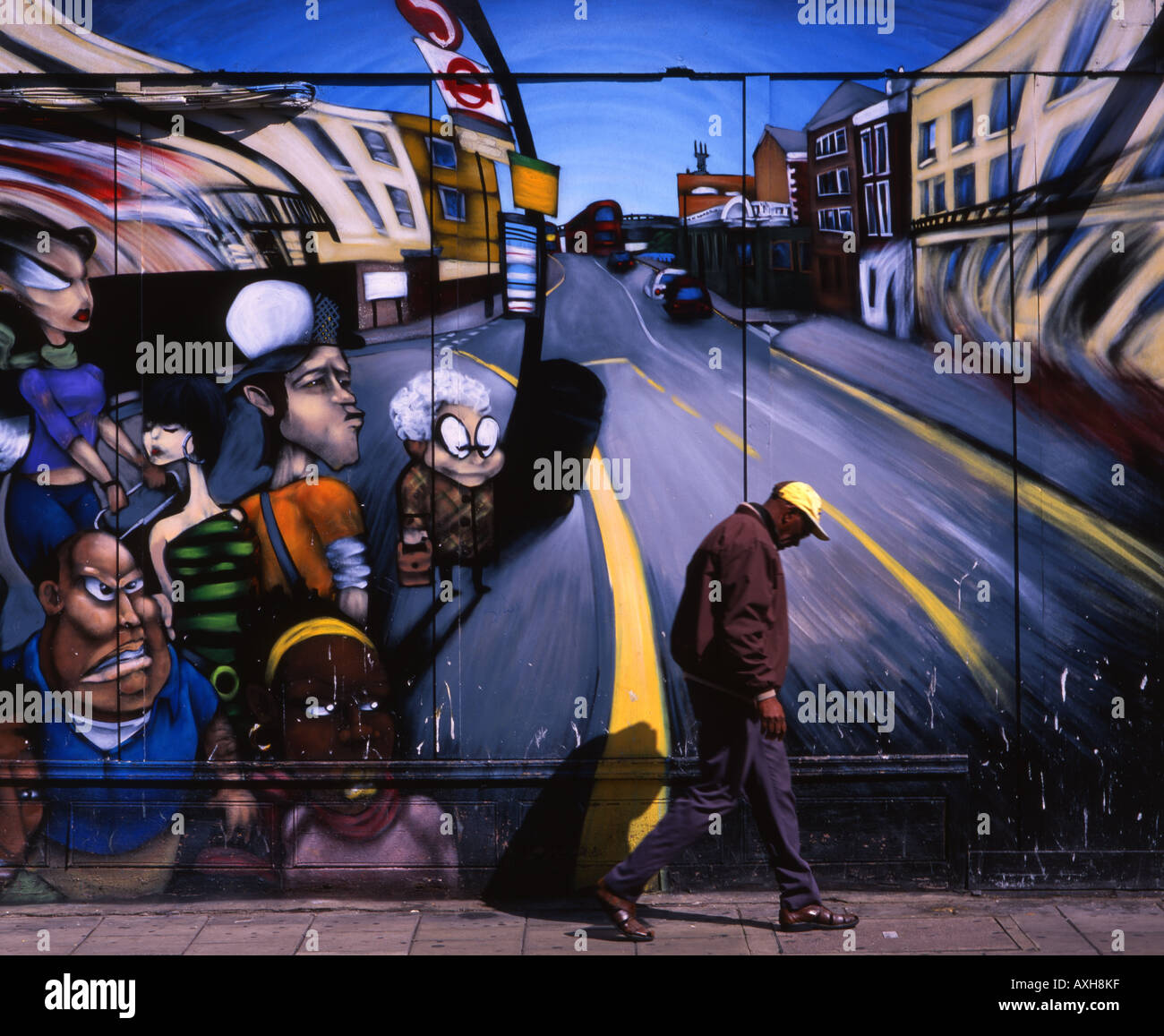 Elderly man walks, head bowed, past a mural in Notting Hill, London, England. Stock Photo