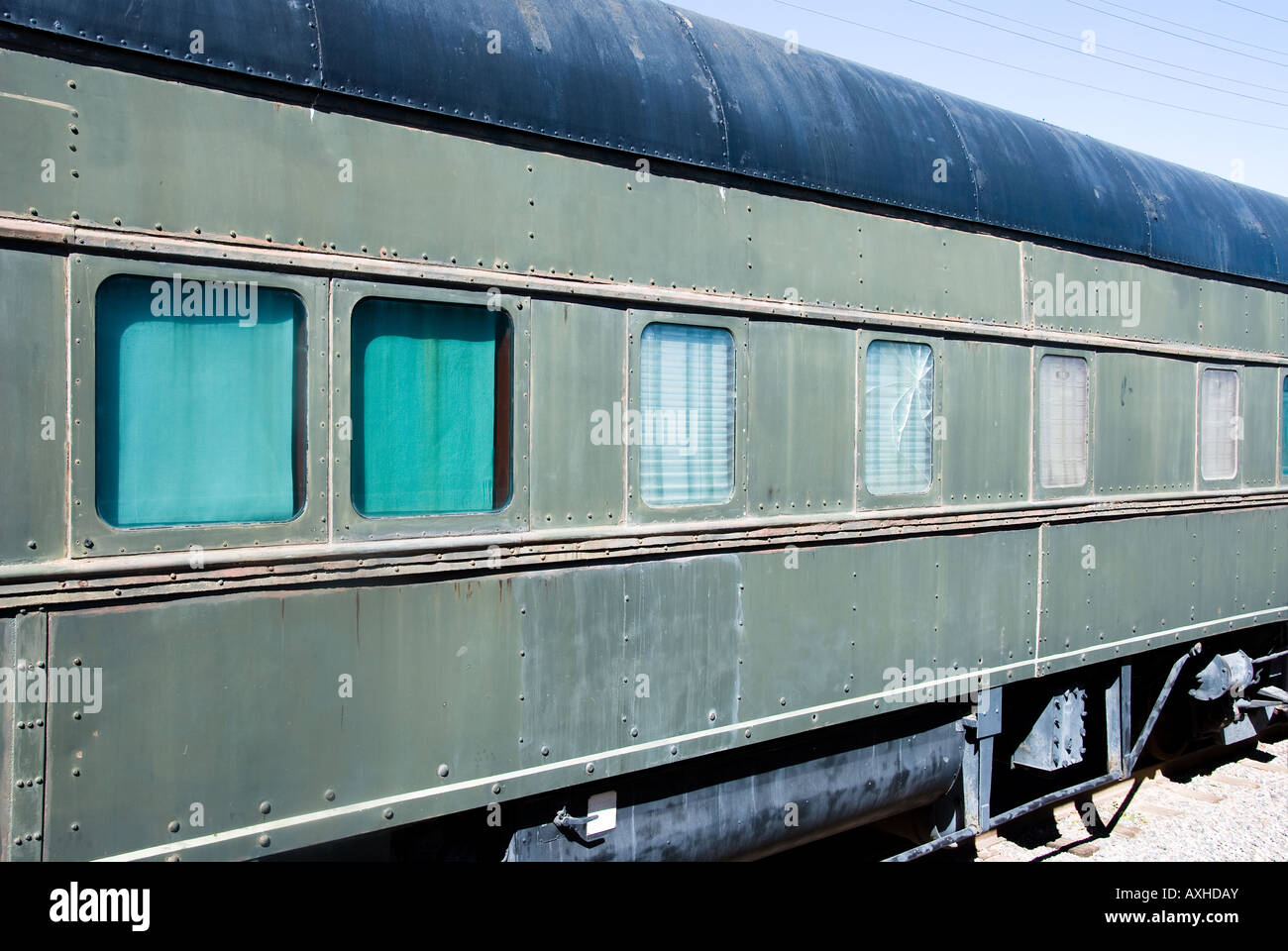 An old passenger train rests along a desert railway station Stock Photo