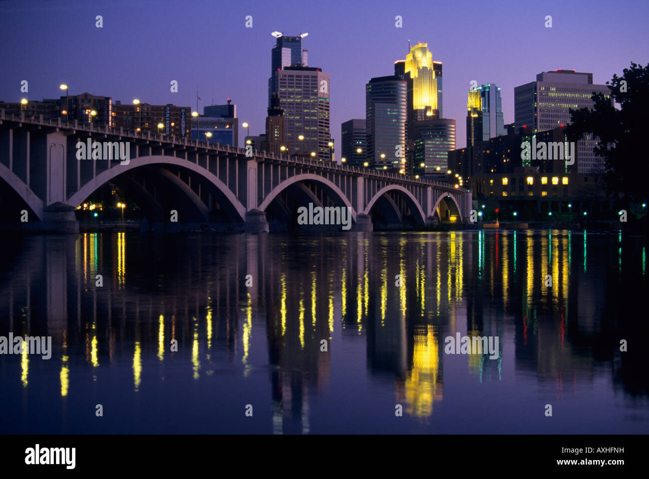 SKYLINE OF MINNEAPOLIS, MINNESOTA, THE MISSISSIPPI RIVER AND THE THIRD AVENUE-CENTRAL AVENUE BRIDGE AT DUSK. Stock Photo