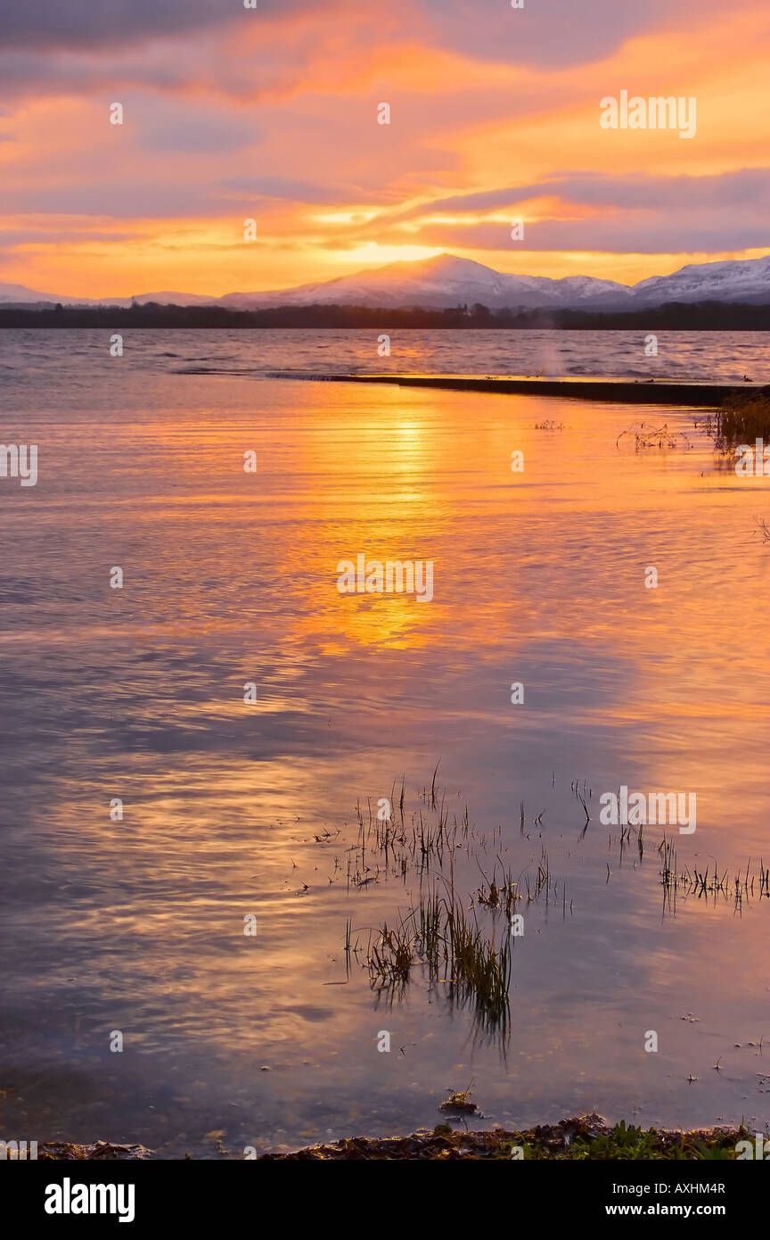 colourfull sunrise on the lakes of killarney showing snow capped mountains in background Stock Photo