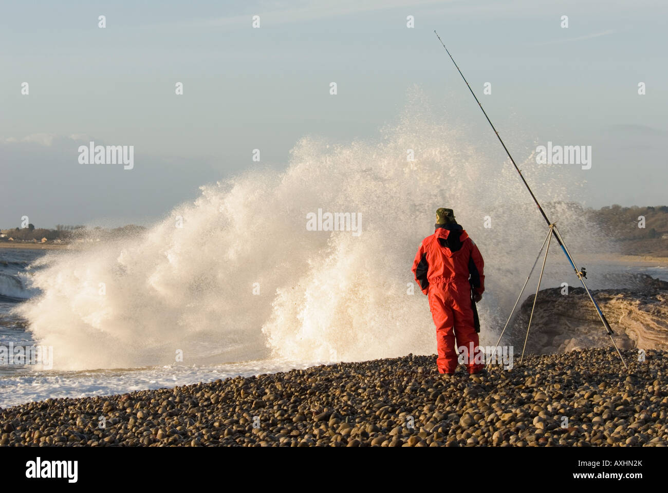 beach angler fishing in rough weather at Ogmore by sea South Wales Stock Photo