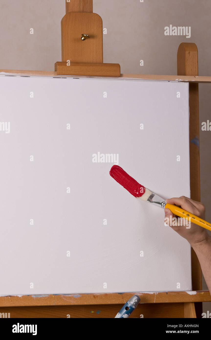 painting on easel with arm hand brush showing colorful Stock Photo - Alamy