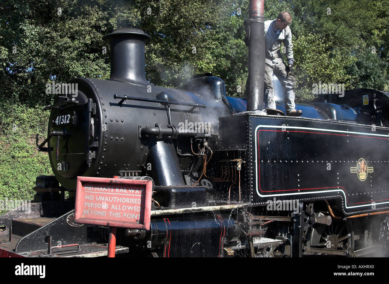 Ivatt Class 2 2-6-2 tank engine takes water at Ropley station, Mid-Hants Railway, near Winchester, Hampshire. Stock Photo