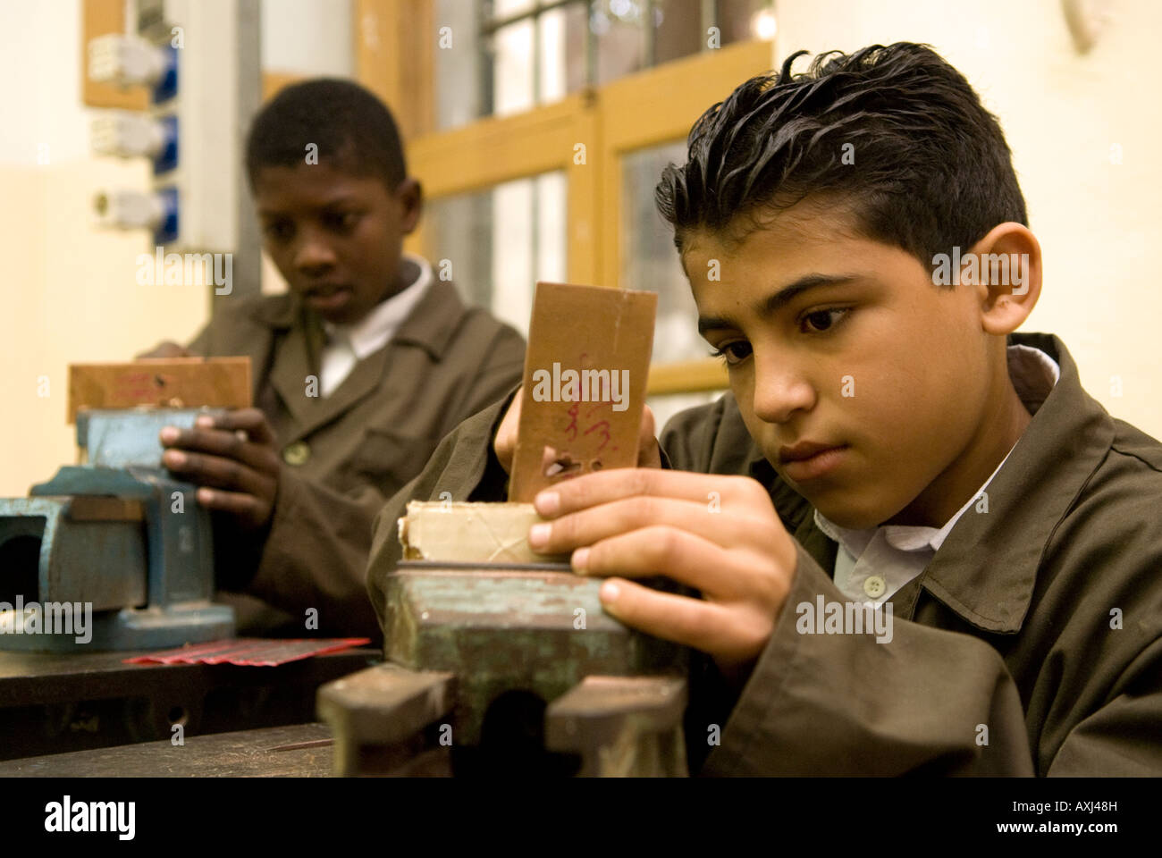 Young boy pupils engaged in copper workshop at the Islamic Arts and Crafts School, Tripoli, Libya. Stock Photo