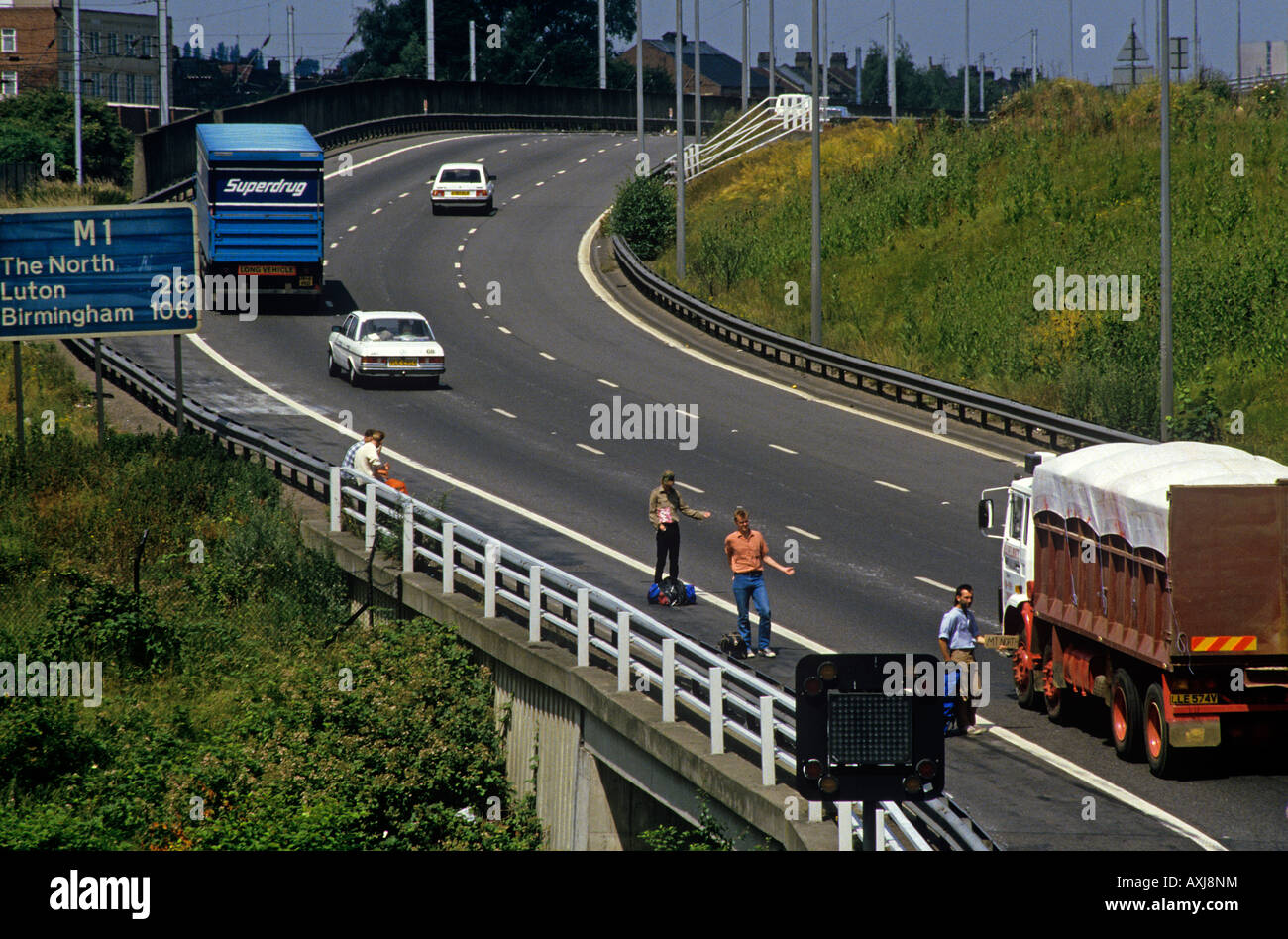 Young Men hitching lifts at the start of the M1 back a few years It used to be much more common Stock Photo