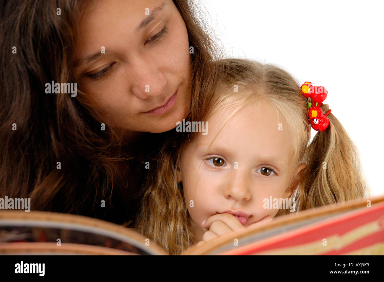 Cute little girl reading book with a young woman Stock Photo