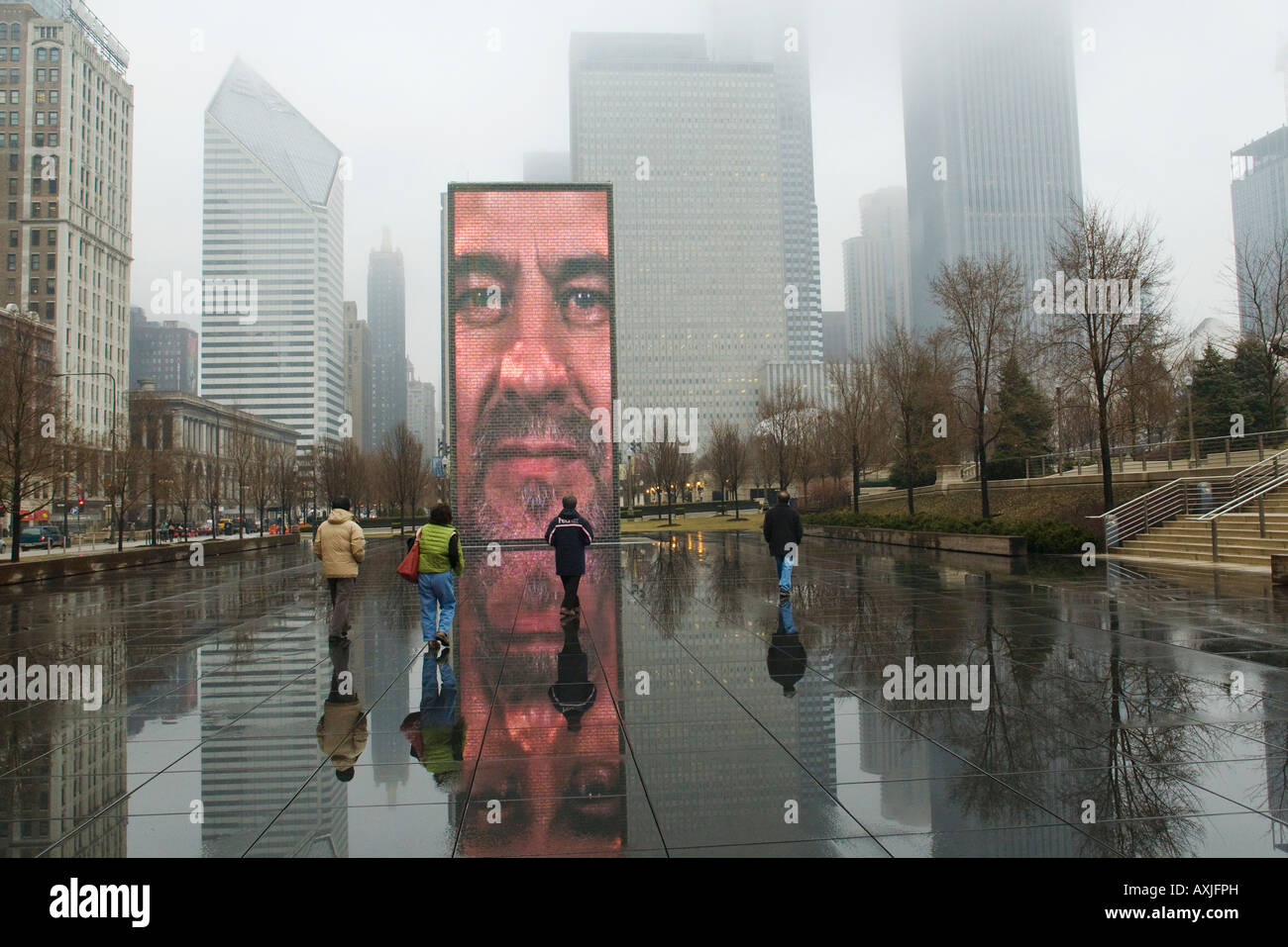 ILLINOIS Chicago Crown Fountain in Millennium Park foggy and rainy day face on video screen reflection visitors to popular site Stock Photo