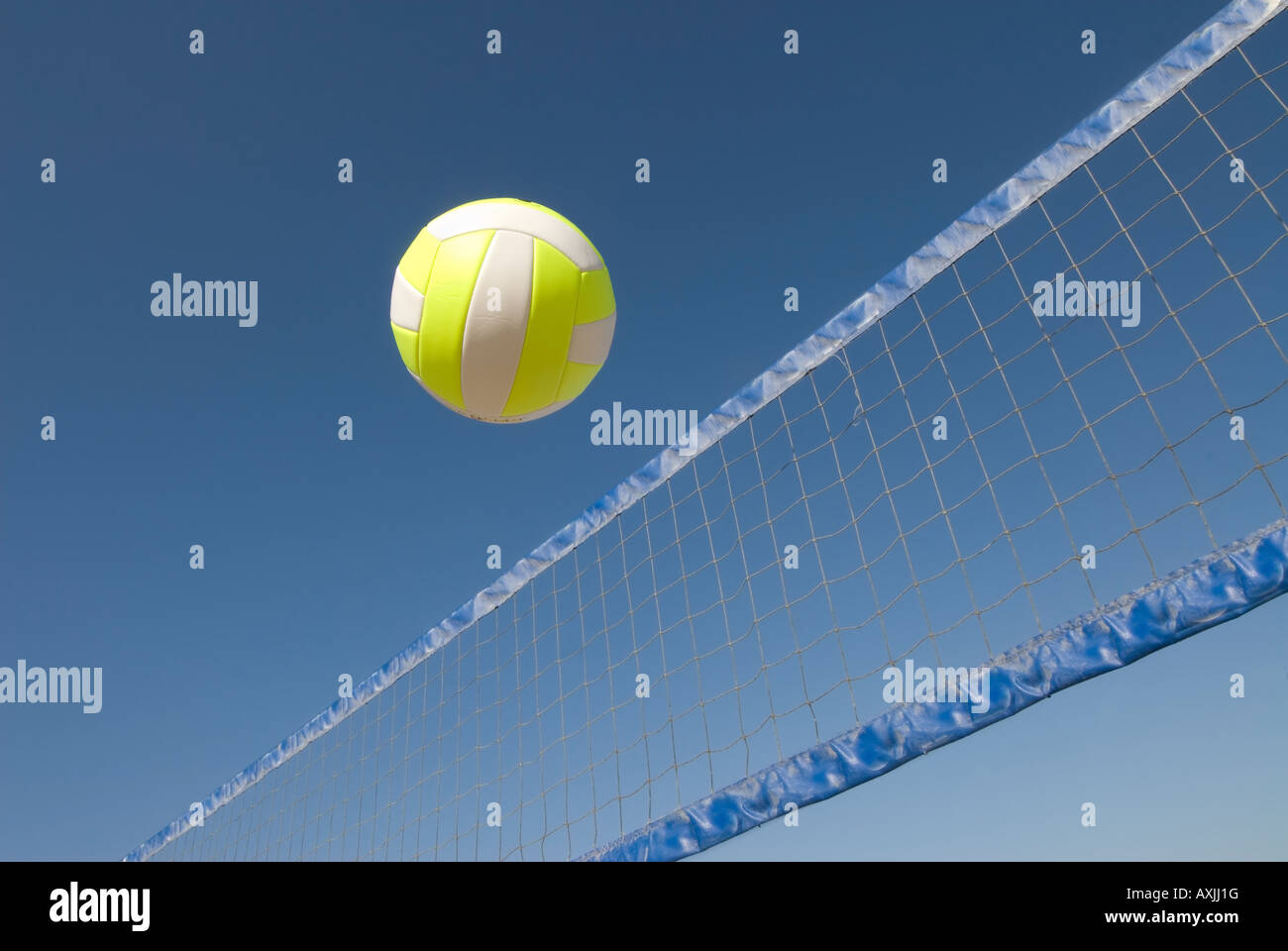 A volleyball player lobs a ball during a game at the beach Stock Photo
