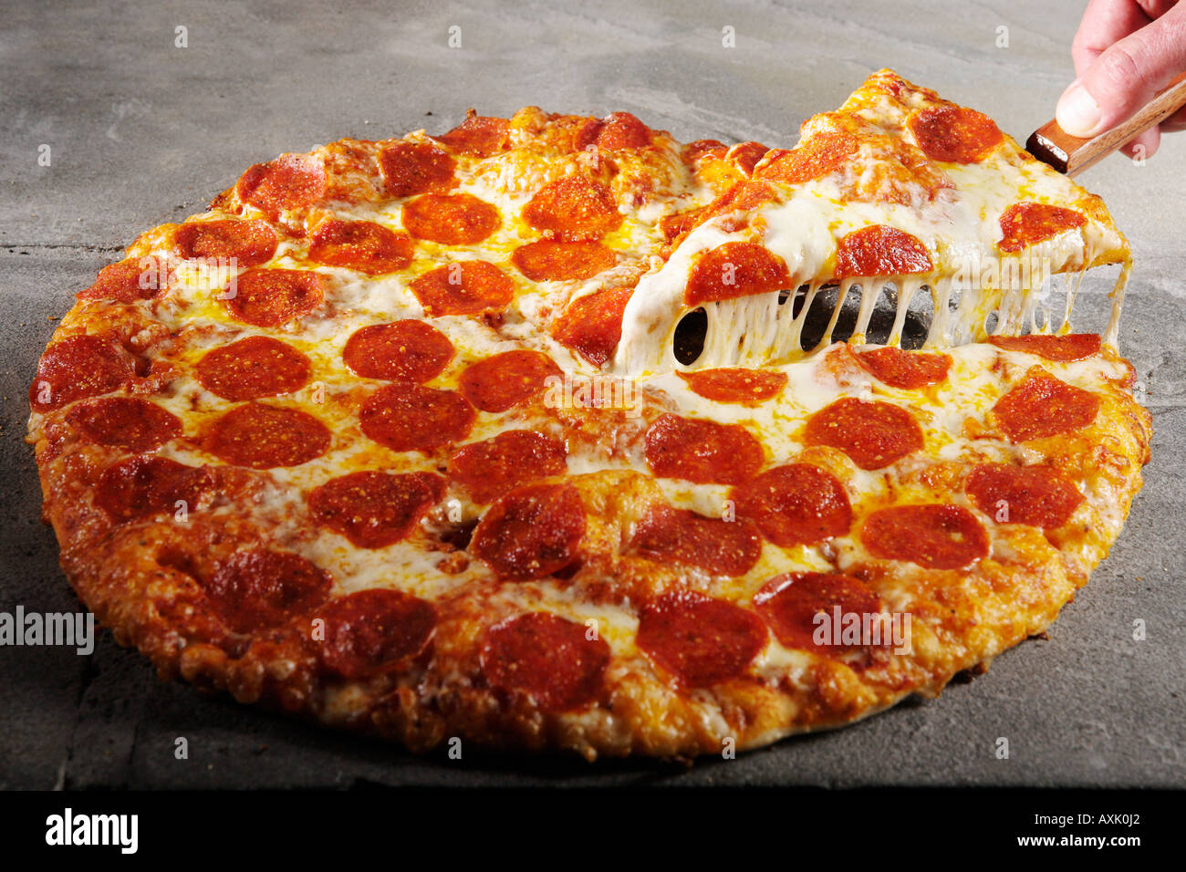 meat pepperoni pizza hand holding slice piece on spatula lifting up Stock Photo 9635617 Alamy