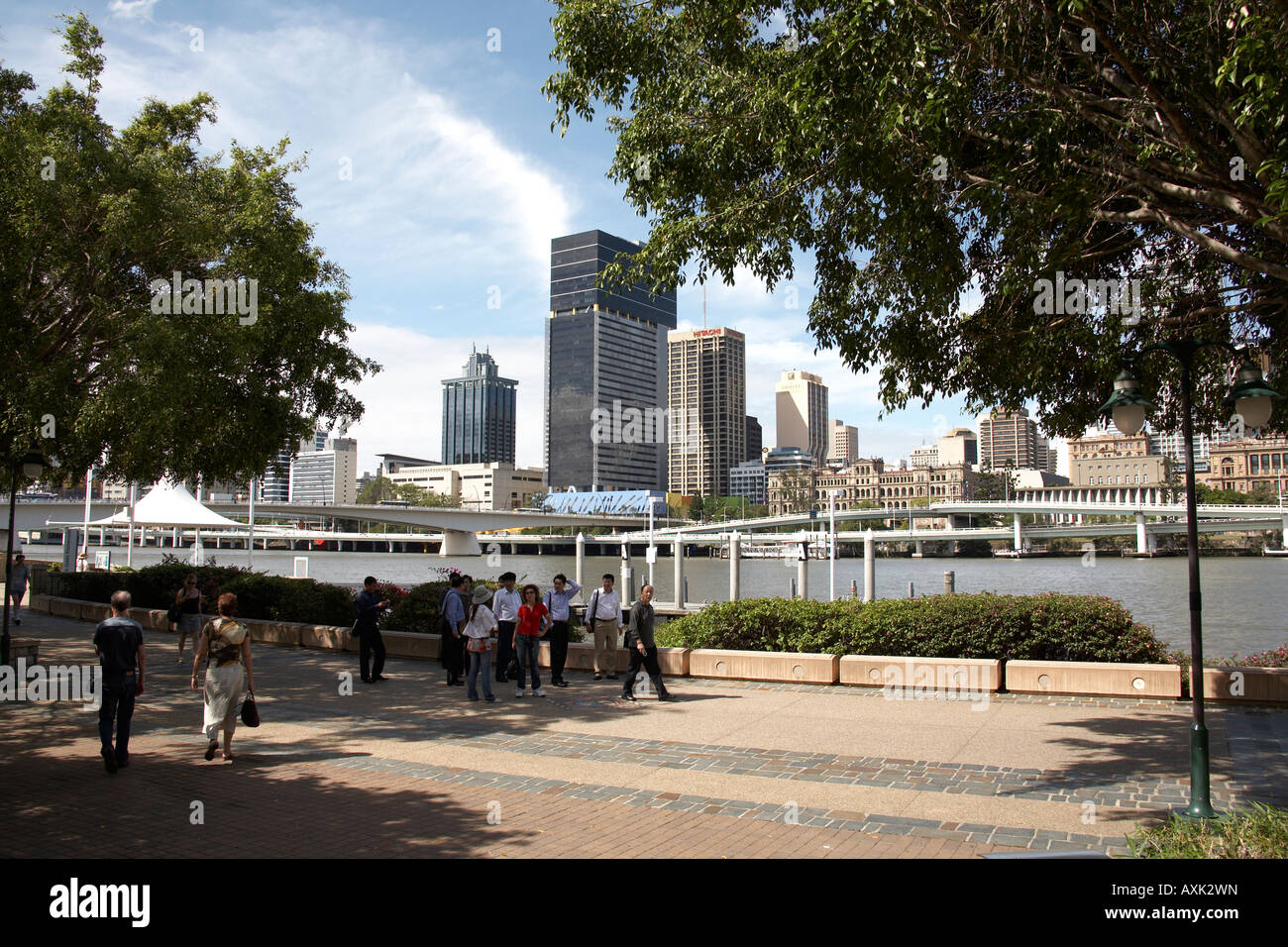 People walking on South Bank with Central Business District beyond river in Brisbane Queensland QLD Australia Stock Photo