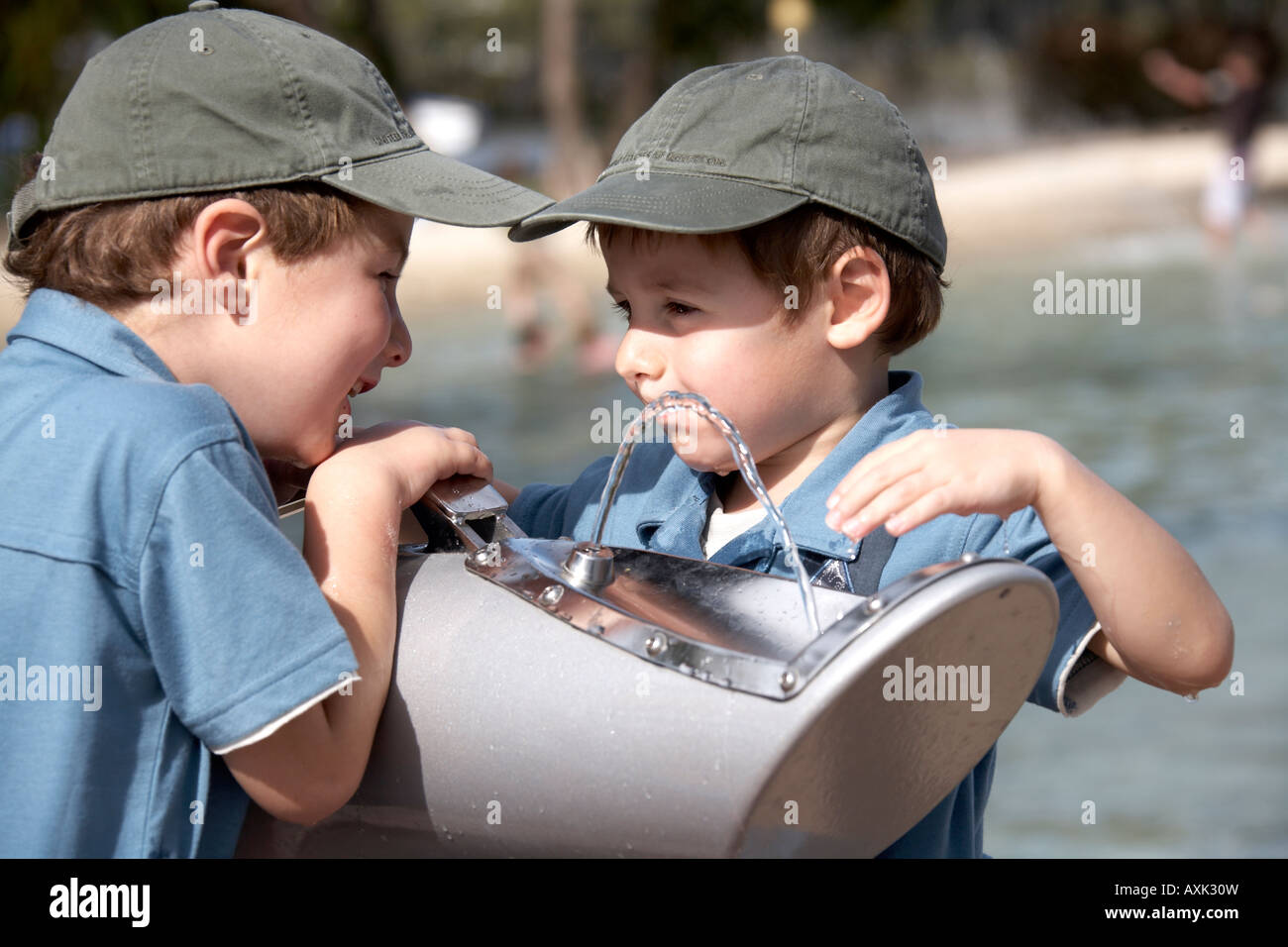 Two young boys children drinking from water fountain on South Bank in Brisbane Queensland QLD