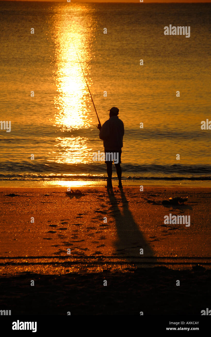 Fisherman at sunrise on Florida beach. Stock Photo