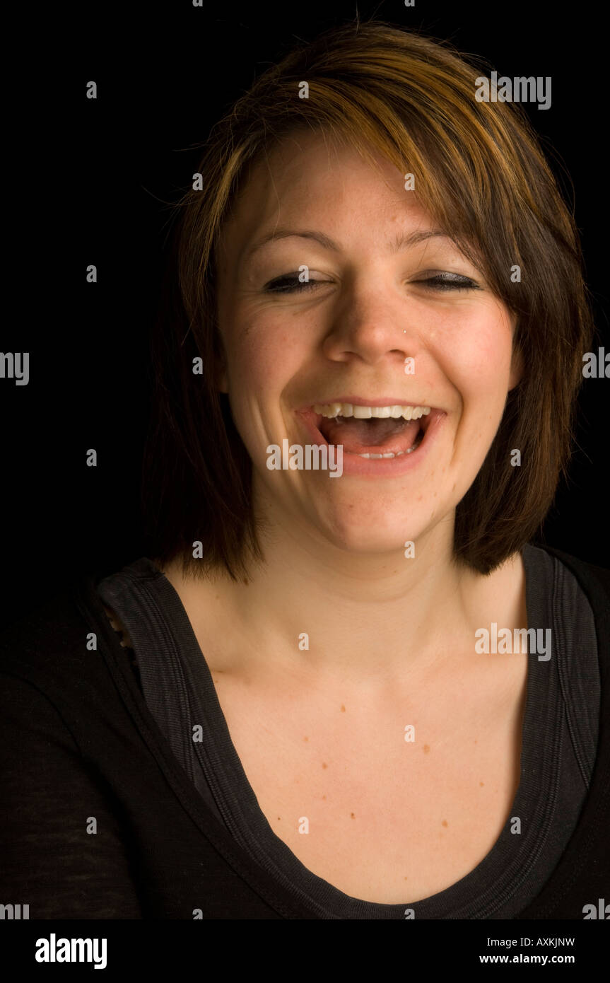 head and shoulders portrait of Laughing young Caucasian woman against ...