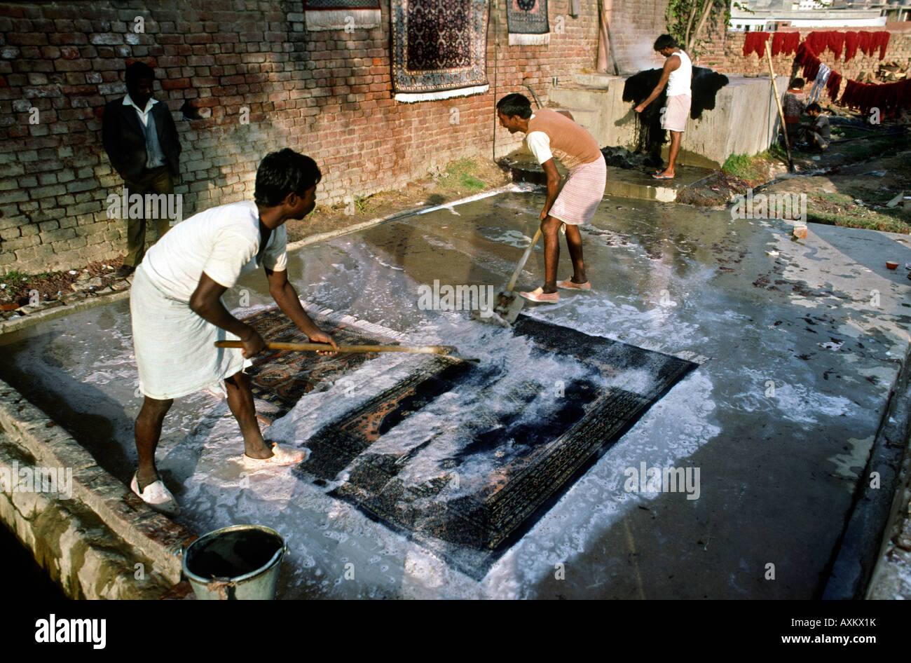 India crafts Uttar Pradesh Agra carpet making men washing newly made carpet Stock Photo