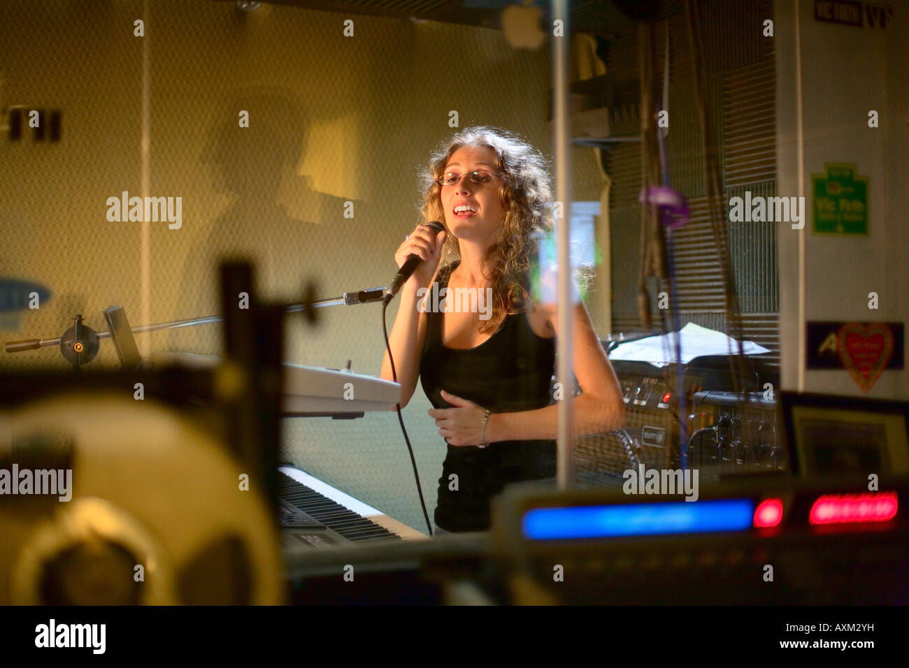 Young woman singing into microphone Stock Photo