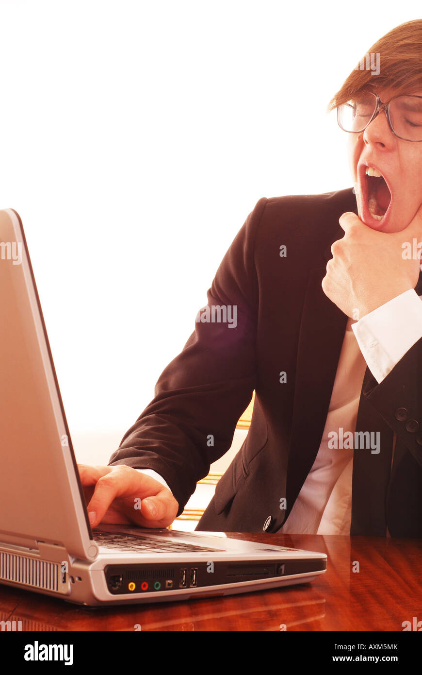 Man yawning on computer - Business Stock Photo
