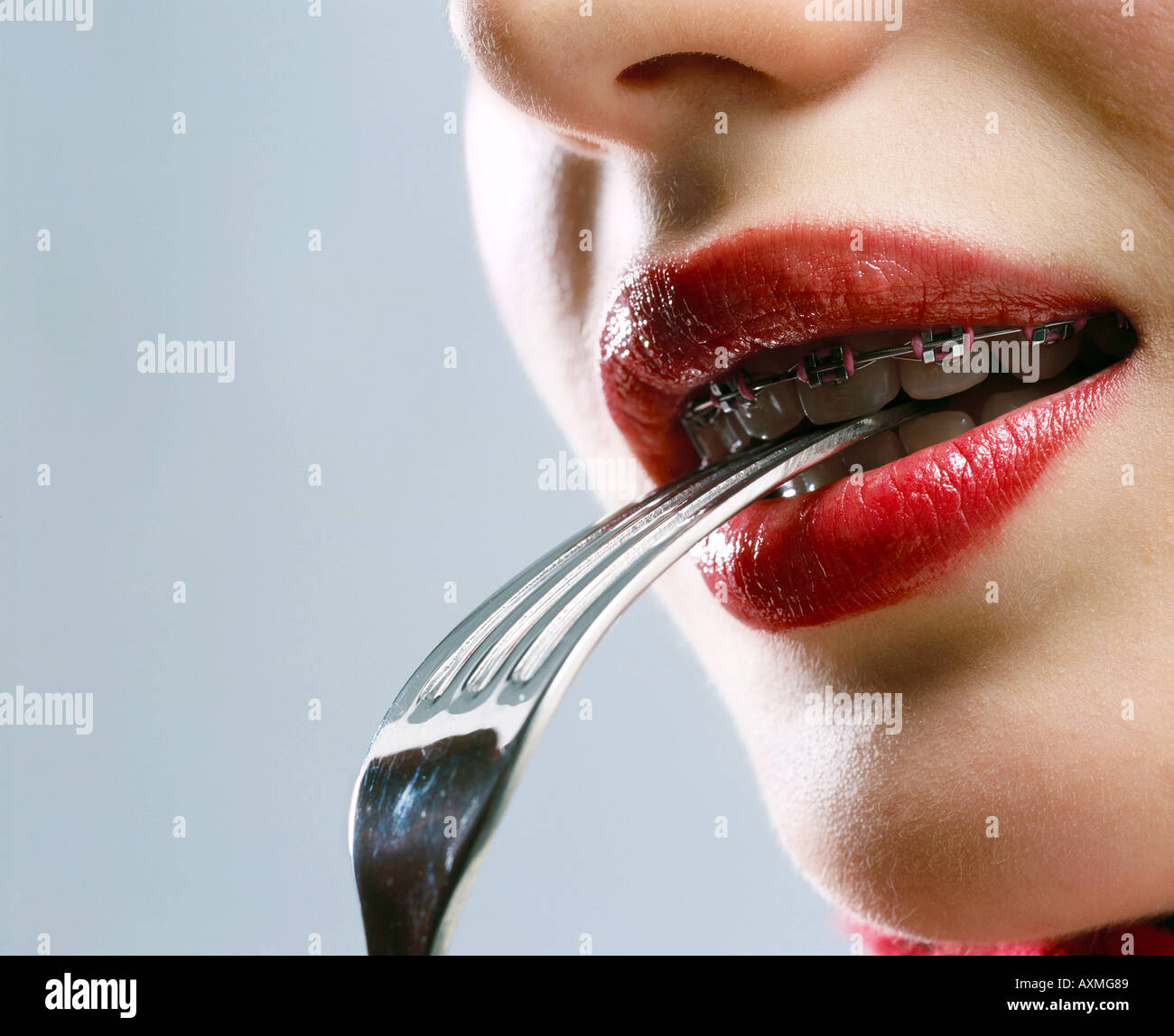 Young woman with a fork in her mouth Stock Photo Alamy