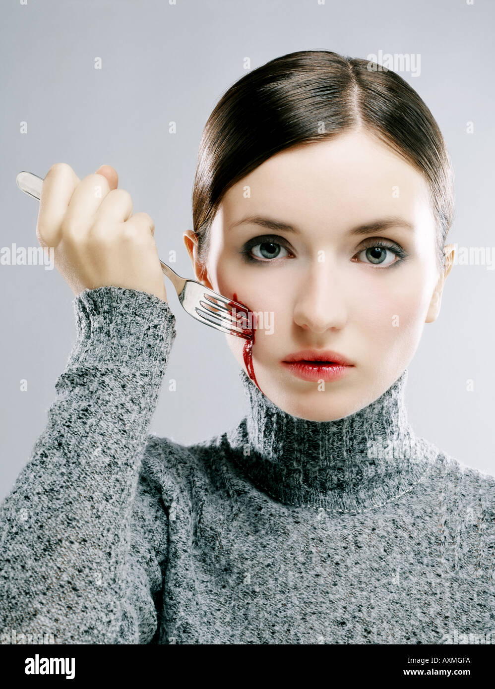 Young woman hurting herself with a fork Stock Photo Alamy