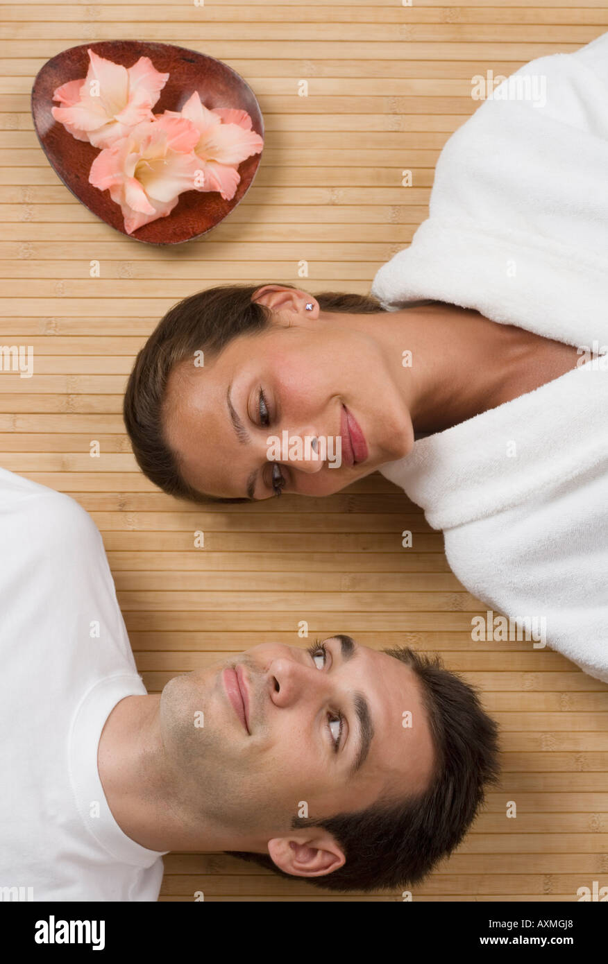 Couple smiling at each other while laying on floor Stock Photo