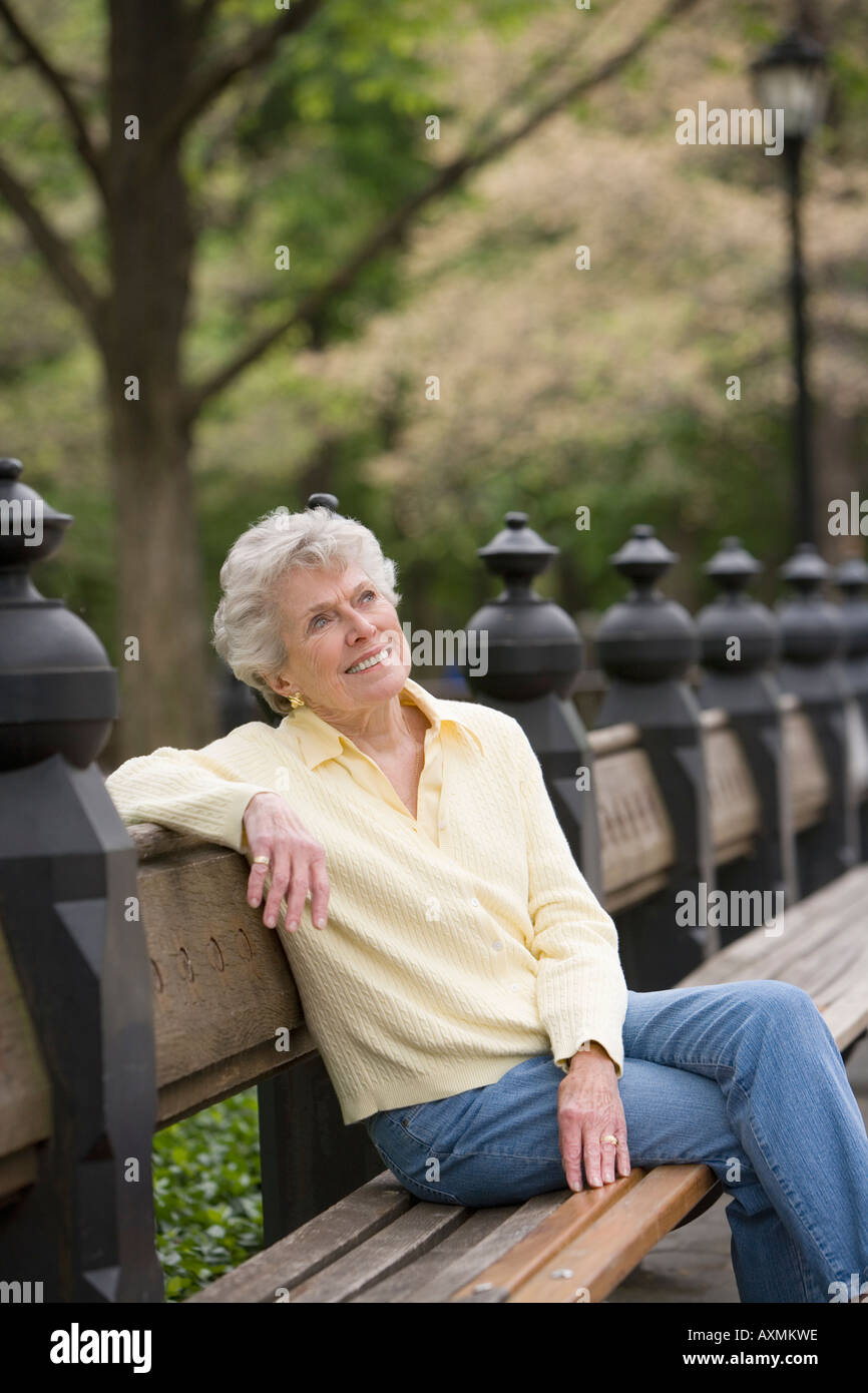 Portrait of woman sitting on park bench Stock Photo - Alamy