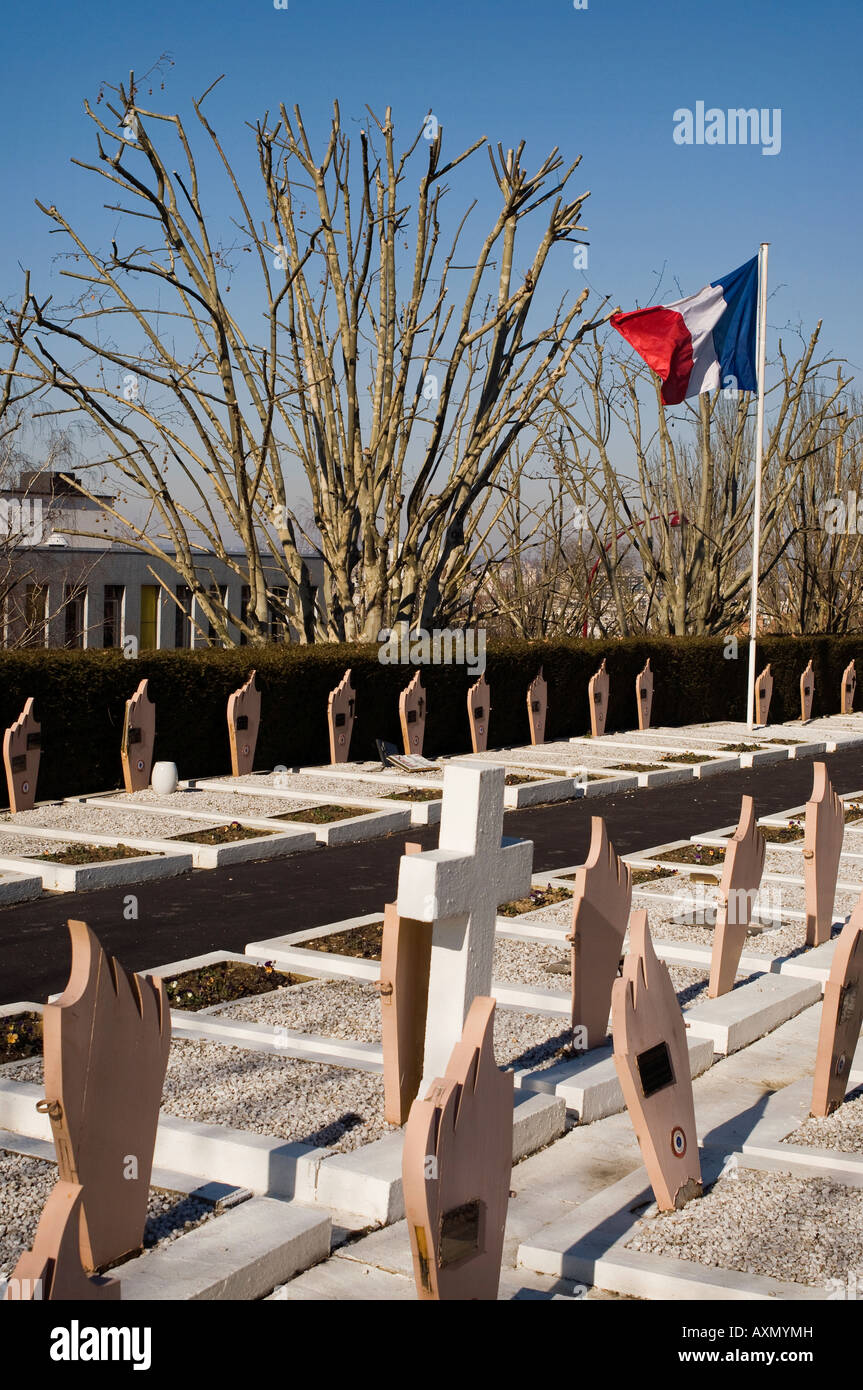 France's tricolour flag flies over military war graves in Lilas Cemetery. Les Lilas, a Paris suburb. Stock Photo