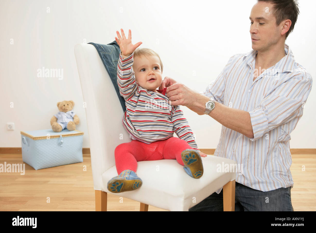 Father putting on son's jumper Stock Photo Alamy